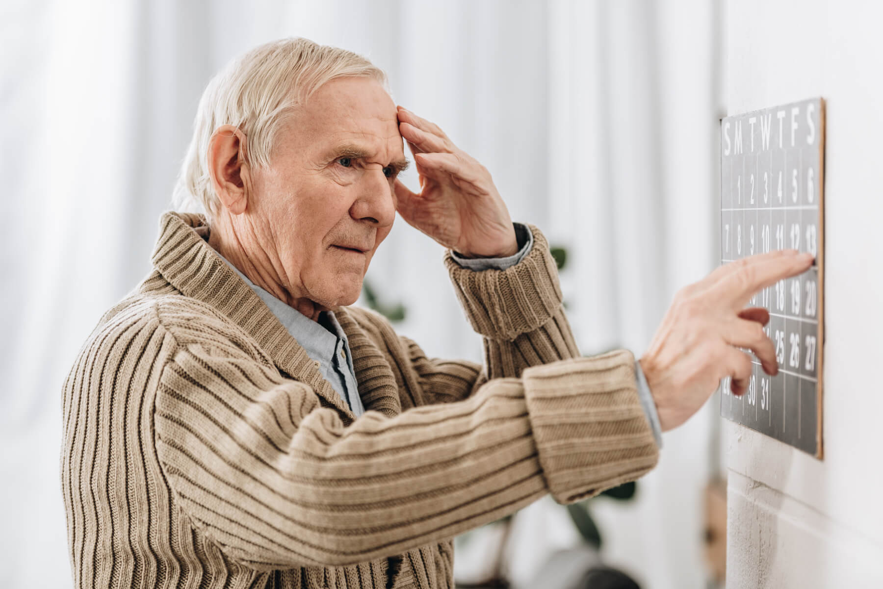 senior man looking at wall calendar and touching h 2023 11 27 05 11 38 utc