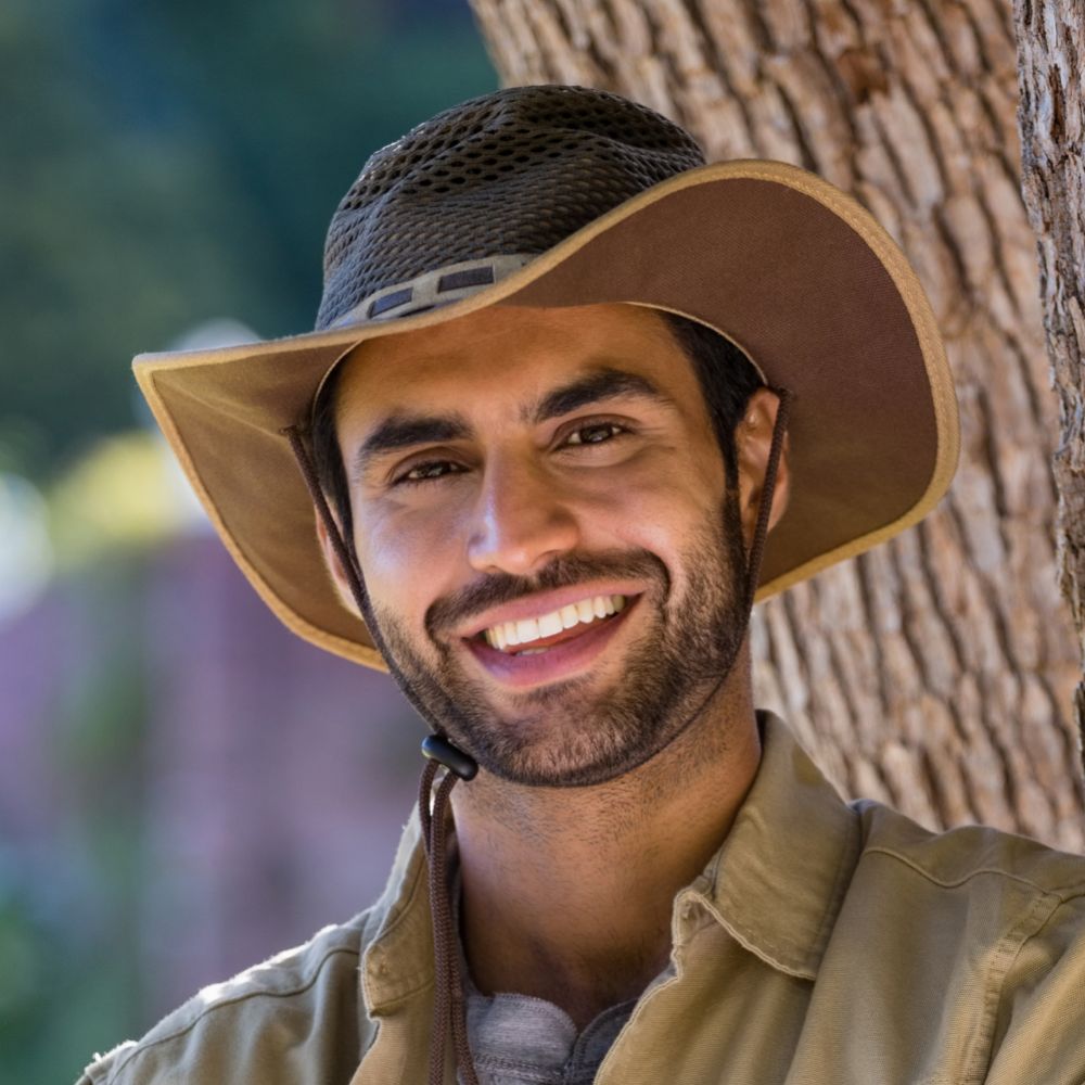 smiling man standing with arms crossed near tree t D8P8B96 1 1